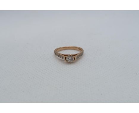 An 18ct rose gold (hallmarked) diamond solitaire ring - The central diamond approx 0.2ct and set with diamond accent shoulder