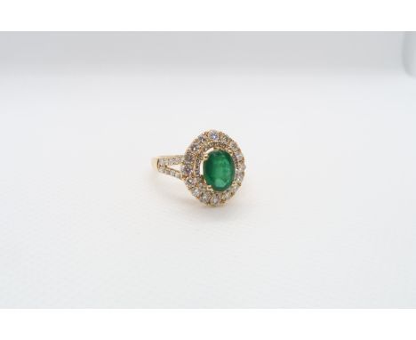 A very good 18ct yellow gold (hallmarked) emerald and diamond ring - the central oval emerald approx 1.5ct set with double ha