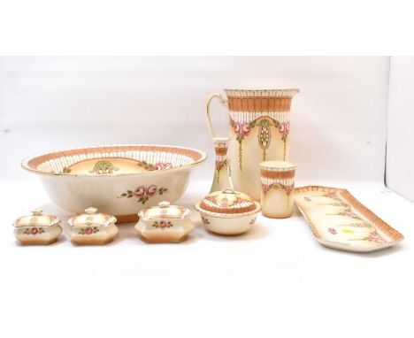 CROWNFORD WARE; an Edwardian nine-piece dressing table set comprising a large wash bowl, 13 x 43cm, a jug, height 30cm, three