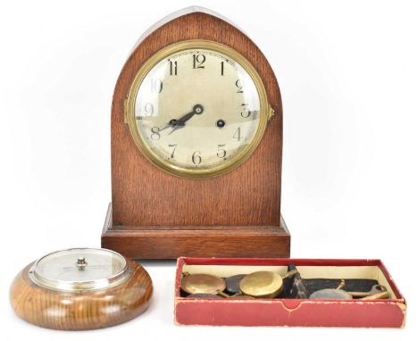 An early 20th century oak cased arch top mantel clock, the brass circular dial set with Arabic numerals, with two winding hol