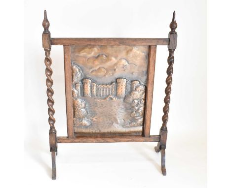 A bronzed and oak fire screen with repoussé bronzed panel of castle with moat, twist side supports to bracket feet, panel 48 