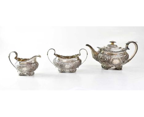 THOMAS WILKES BARKER; a George III hallmarked silver three-piece tea service of squat baluster form, with chased floral decor