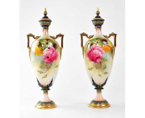 ROYAL WORCESTER; a pair of twin-handled lidded vases on circular footed base, painted with roses by Jenny Lander, shape no.24
