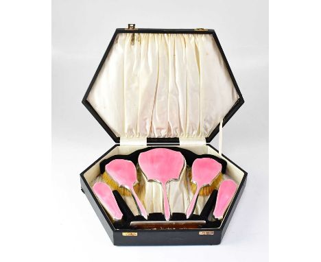 A George V hallmarked silver and pink guilloché enamel dressing table set, comprising a mirror, two hairbrushes, two clothes 