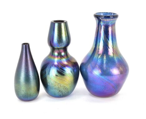 IN THE MANNER OF JOHN DITCHFIELD OF GLASFORM; three dark iridescent glass vases, the tallest with mainly blue finish, height 