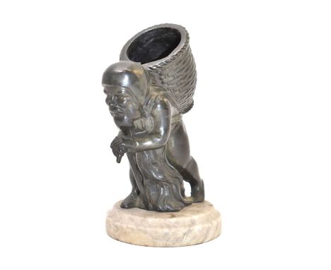 An early/mid-20th bronze gnome figure with walking stick and basket on his back, on a circular chamfered stone base, height 1