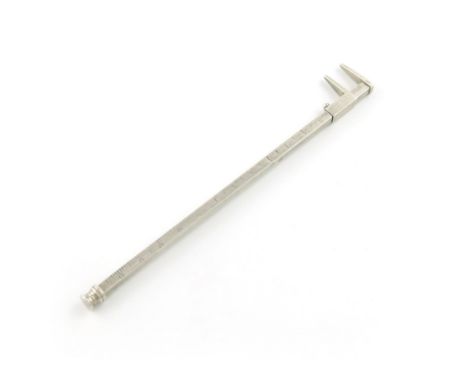 A novelty silver pencil, unmarked, modelled as a ruler with callipers, calibrated in inches, length 16.5cm. Provenance: The K