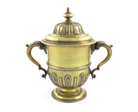 A George II silver-gilt two-handled cup and cover, by Peter Archambo, London 1729, circular form, leaf capped scroll handles,