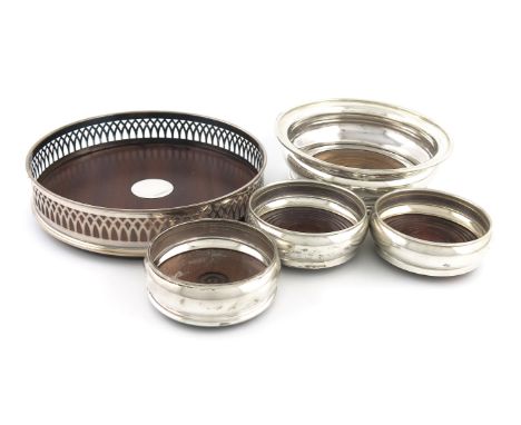 A small collection of five silver wine coasters, comprising: one by James Dixon and Sons, Sheffield 1934, circular form, turn