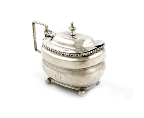 A George III silver mustard pot, marks worn, London 1810, rounded rectangular form, scroll handle, hinged cover with an urn f