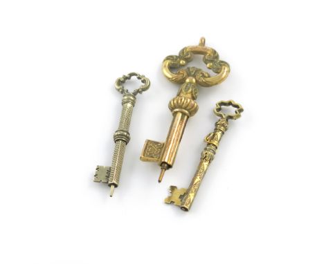 Three Victorian novelty silver-gilt and gilt-metal pencils, modelled as keys, one fluted, one with engine-turned decoration a