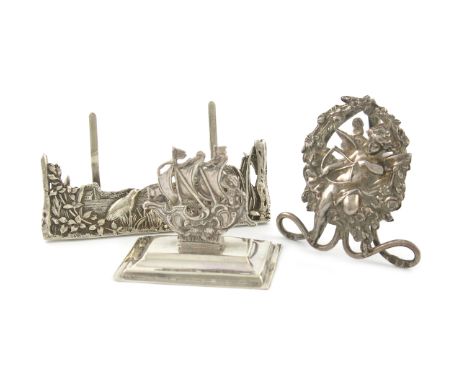 A small mixed lot of silver menu card holders, various dates and makers, comprising: one modelled as a galleon, by Mappin and