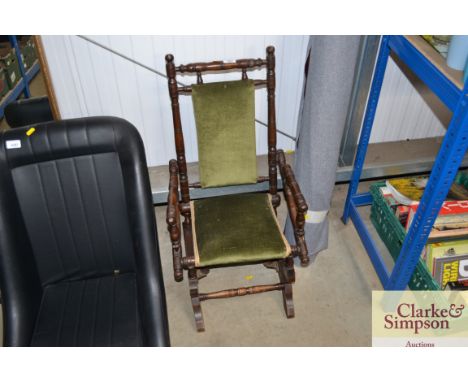 A green upholstered vintage child's rocking chair