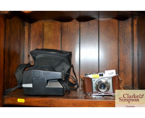 A Polaroid camera together with a Kodak camera