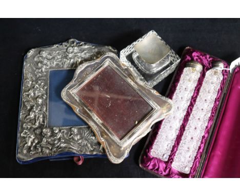 Two silver topped cut glass toilet jars, on by Sampson Mordan, two photograph frames and a silver mounted inkwell.