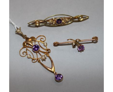 An Art Nouveau 9ct gold amethyst and seed pearl set pendant and two similar brooches.