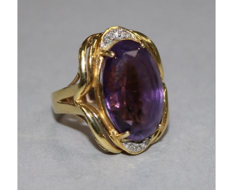 An 18ct gold, amethyst and diamond set oval dress ring, size K.