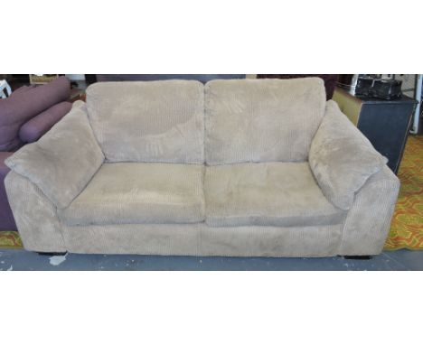 A modern beige fabric two seater sofa.