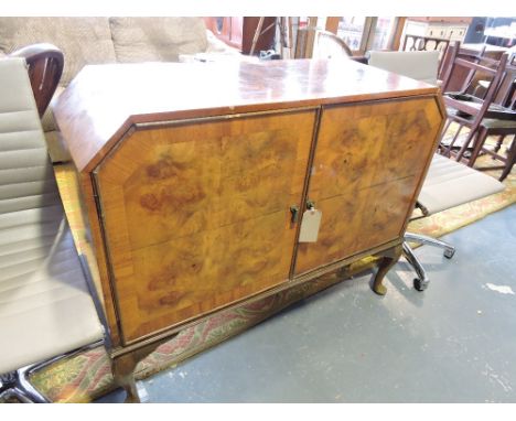 An Art Deco style walnut sideboard, the rectangular top with canted ends above an arrangement of two door enclosing drawers a