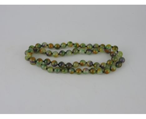 A jade necklace, of uniform green, yellow and purple beads, L. 80cm.