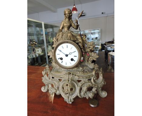 An early 20th Century cast gilt spelter mantel clock with circular white enamel dial