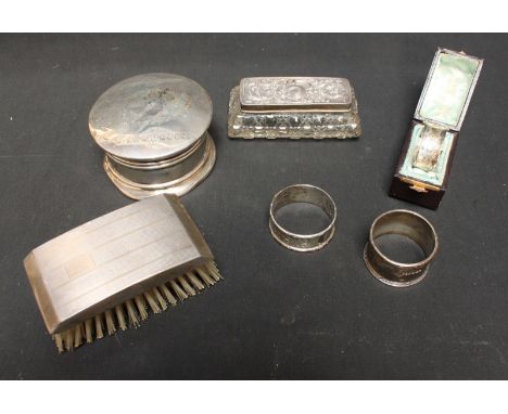 A collection of silver items including a circular jewellery box and cover (af), an engine turned silver clothes brush, a glas