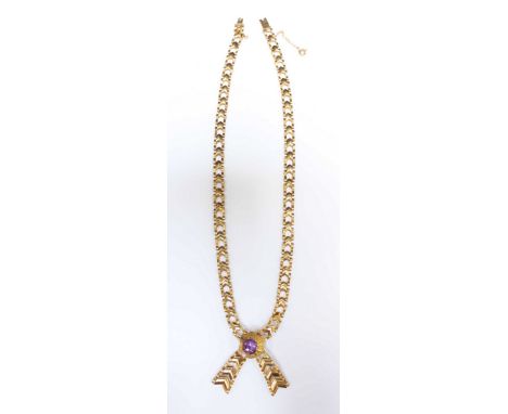 A 9ct gold and amethyst crossover necklace, with central amethyst in a flower head mount, the chain formed as stylized arrow 