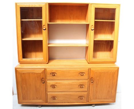 A 20th Century light elm 'Ercol', side cabinet with central storage compartment above shelf flanked by two glazed cupboards e