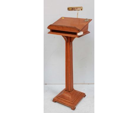 An oak lectern, with open paper shelf, square spreading base, fitted with brass reading light and a stained walnut prayer tab