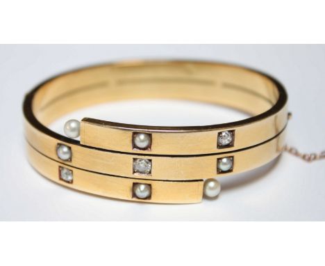 A Victorian diamond and yellow metal stiff bangle, set with three diamonds and set in unmarked yellow metal. 27 grams.