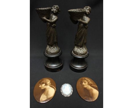A pair of patinated spelter figures of young girls carrying baskets, 24cm high, together with a pair of sepia-photographic po