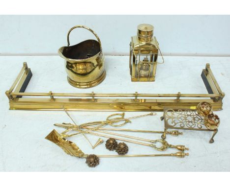 A large collection of brassware including a fender, coal bucket, fire tools, a ships lantern and other items.