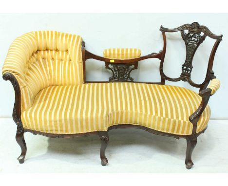 An Edwardian mahogany conversation seat, with ornately carved and pierced show wood frame, button upholstered end and open op