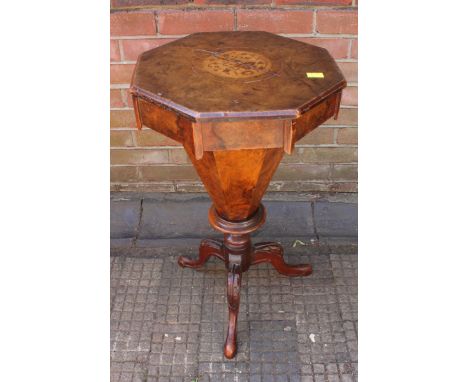 A Victorian figured walnut octagonal sewing table, the top with inlaid flowers, opening to reveal a fitted interior, with oct