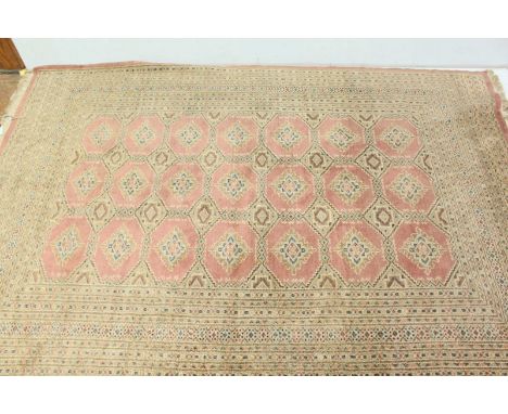 A large Persian pink ground carpet, decorated with a central panel of 21 diamond shapes surrounded by geometric borders. 281 