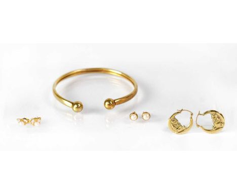 A group of 9ct yellow gold jewellery, comprising a torc bangle, a pair of Winnie-the-Pooh hoop earrings, and two pairs of stu