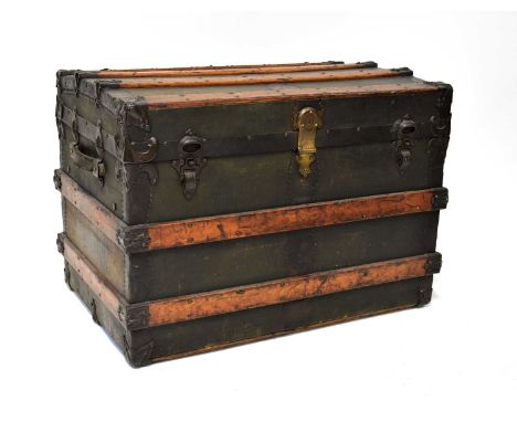 An early 20th century leather and wood bound canvas-covered, dome-topped travel trunk, with leather handles, studded decorati