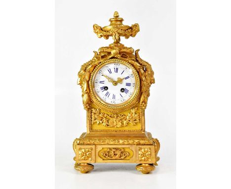 A 19th century French eight-day ormolu mantel clock surmounted with lidded urn with twin goat mask handle and swag decoration