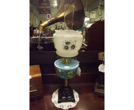 Oil lamp with brass column and painted blue bowl and tulip shade. 