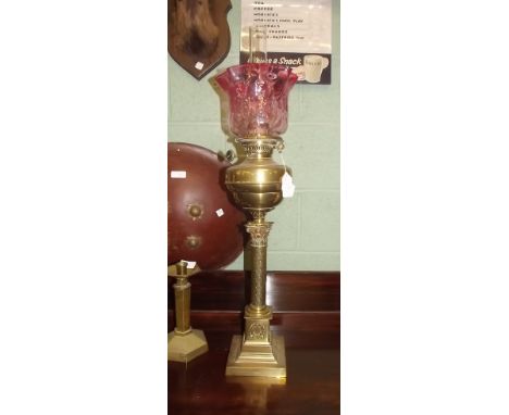 Victorian oil lamp with brass column and bowl and ruby glass tulip shade. 