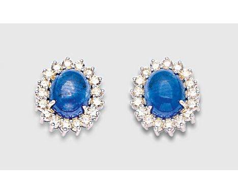 Weißgold, gest. 750. Zentral besetzt mit 2 nahezu kornblumenblauen Saphir-Cabochons von zus. ca. 7,84 ct., entouriert von Bri