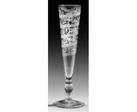 Farbloses Glas. Flötenform. Stark ausgestellter, leicht ansteigender Fuß, Balusterschaft, hohe, konische Kuppa. Spiralförmig 