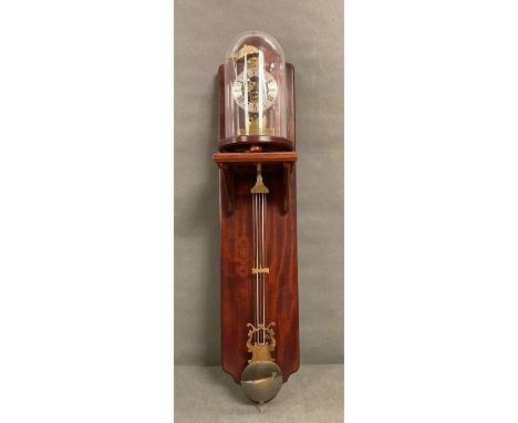 A wall clock with glass dome