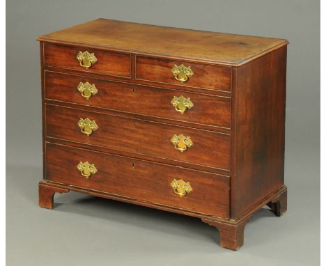 A George III mahogany crossbanded chest of drawers, with moulded edge above two short and three long graduated drawers with b