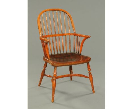 A Windsor armchair, with plain stick back, solid seat, turned legs and crinoline stretcher.  