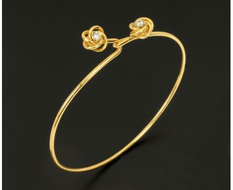 A 14 ct gold bangle, with crossover sprung setting and with clear stone to each terminal, stamped "14 k".  64 mm x 55 mm, CON