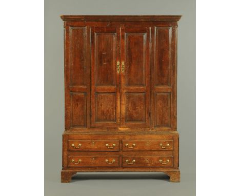 A George III oak cupboard, with detachable moulded cornice above a pair of panelled cupboard doors opening to hanging space, 