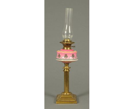 A Victorian oil lamp, with brass column and pink and clover leaf reservoir. 