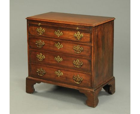A small George III mahogany chest of drawers, with slide above four long graduated drawers with brass drop handles, pierced b