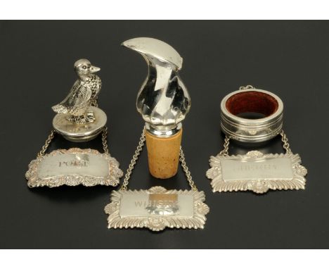 Three silver plated decanter labels, two bottle stoppers and drip ring.